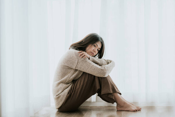 женщина с депрессией сидит одна на полу
