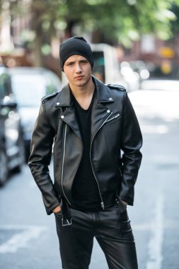 Şehir sokak şapka, pantolon, ceket ve t-shirt ayakta ile siyah stil deri kıyafet giyen hipster adam 
