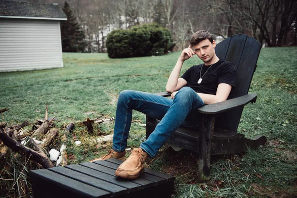 男は農村地域で彼の家の裏庭に木の椅子に座って屋外 — ストック写真