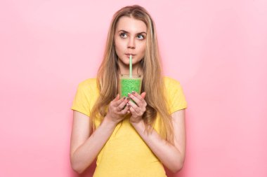 Yeşil smoothie içmeye ve sağlıklı beslenme Detoks gıda hakkında düşünme sevimli genç kadın