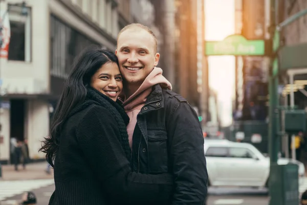 快乐的年轻成人多元文化的夫妇在爱拥抱和微笑在纽约市街道 — 图库照片
