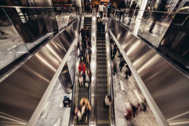 Alışveriş merkezinde hareket eden bir yürüyen merdiven insanlar perakende mağazalarında şeyler satın almak 