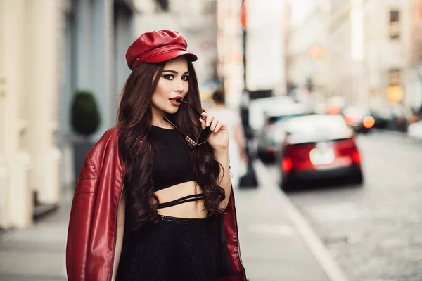 赤いジャケット サングラスを着て街の通りでポーズをとってメイクアップを持つ美しいファッショナブルなセクシーな女性 — ストック写真