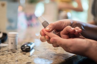 Kadın evde diyabet, kan şekeri ve glikoz ölçüm sistemi kullanıyor.