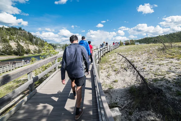 Tourists take a walk on geysers in Yellowstone National Park