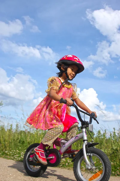 可爱的女孩骑自行车与公主装备在丹麦 — 图库照片