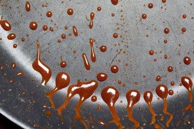 Erimiş karamel sosunun ayrıntıları bir tavada dinleniyor.