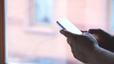 Genç yetişkin adam yazarak ile iki el 4k yakından Smartphone üzerinde