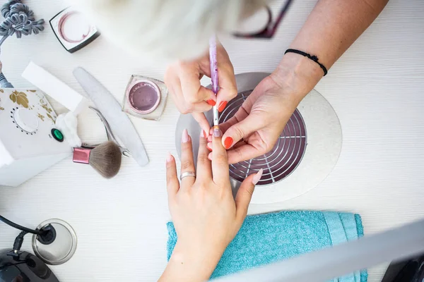 Encerramento de Manicurista Aplica Nail Gel polonês em Dedo. Menina cl — Fotografia de Stock