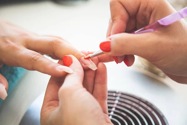 Encerramento de Manicurista Aplica Nail Gel polonês em Dedo. Menina cl — Fotografia de Stock