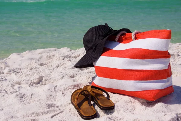 躺在沙滩上的沙滩袋 帽子和凉鞋 免版税图库照片