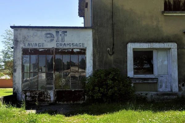 Před starou mechanickou garáží opuštěnou ve venkovských oblastech — Stock fotografie