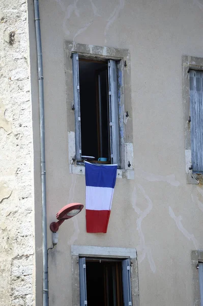 French flag hanging on a window in honor of the passage of the T — Stock Photo, Image