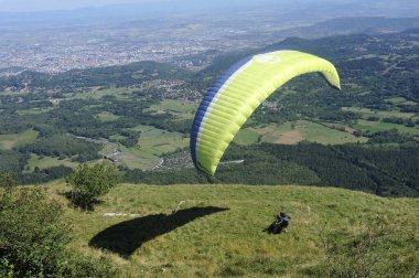 Puy de Dome volkanları üzerinde paraşütçüler uçuyor.