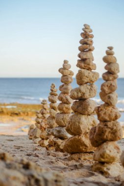 Sarı sandy Beach, günbatımı vurdu arka plan üzerinde okyanus ile taş denge