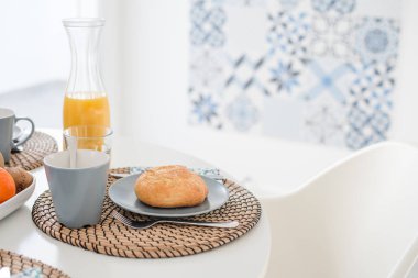 Gri arka planda kızarmış ekmek ve bir bardak meyve suyu tabağı, üst manzara.