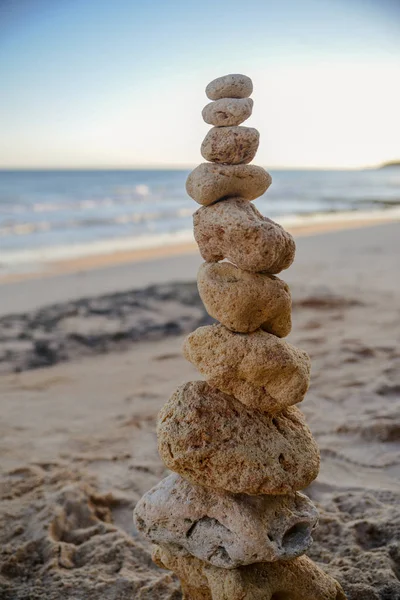 Sarı sandy Beach, günbatımı vurdu arka plan üzerinde okyanus ile taş denge