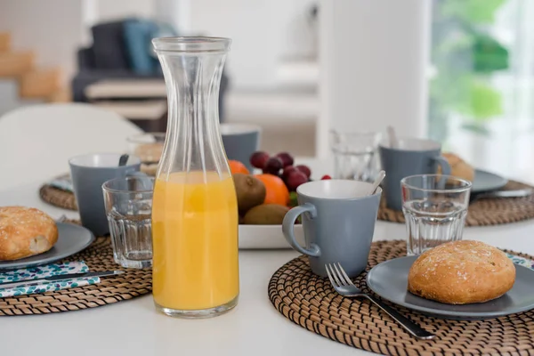 Gri arka planda kızarmış ekmek ve bir bardak meyve suyu tabağı, üst manzara.