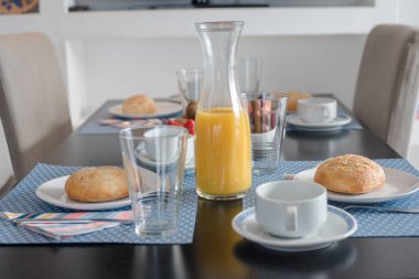 Beyaz tabakta taze kabuklu ekmek ve bir bardak meyve suyu ile tabak