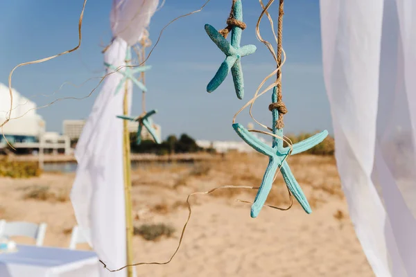 Arco nuziale decorato con stelle di pesce e paglia, su una spiaggia di sabbia per la cerimonia nuziale . — Foto Stock