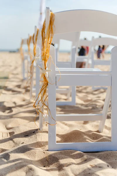 Sedie da sposa decorate con stelle di pesce e paglia, su una spiaggia di sabbia per cerimonie nuziali — Foto Stock