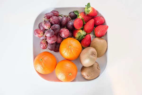 Campuran segar buah manis di atas piring putih — Stok Foto