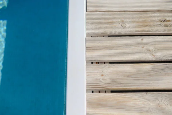 Lado da piscina com fundo de água azul — Fotografia de Stock