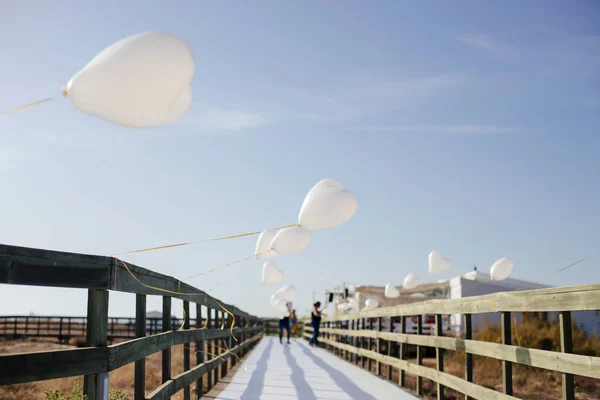 Weiße Luftballons herzförmig fliegen in blauem Himmel. Liebe. Feiertagsfeier. — Stockfoto