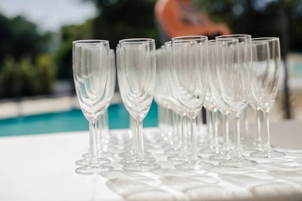 Copa de champán con juego de comedor preparar la cena en la mesa junto a la piscina —  Fotos de Stock