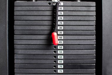 Spor salonunda ağır ağır siyah levhalar yığılmış. Spor simülatörü kalıpları.