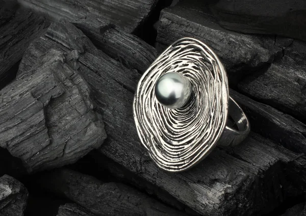 Anel de jóias com pérola, em carvão preto como fundo — Fotografia de Stock