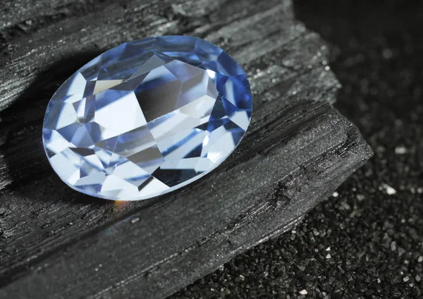 Sfaccettato blu gioielli gemma zaffiro su sfondo carbone nero — Foto Stock