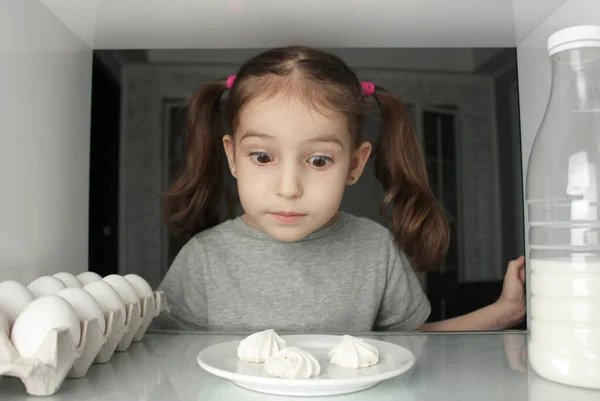 冷蔵庫からの眺め 楽しいです子供の女の子発見ケーキ — ストック写真