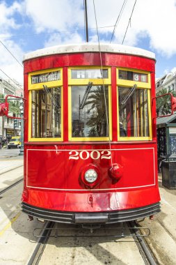 red trolley streetcar on rail in New Orleans in the French Quarter clipart