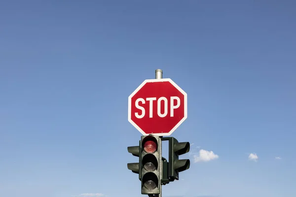 red traffic sign and stop sign under clear blue sky