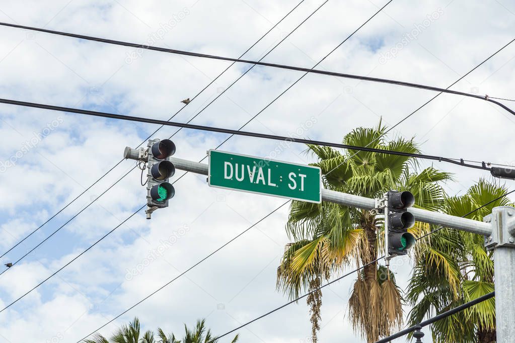 street name duval street with green traffic light in Key West under blue sky