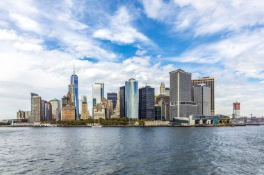 Mavi bulutlu gökyüzü altında feribot ile new York Skyline