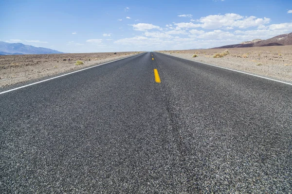 Death Valley road straight across the desert to the mountains in the distance