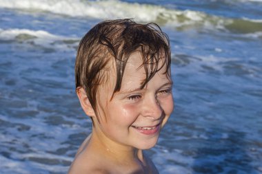 mutlu çocuk mavi denizin dalgaları sahiptir