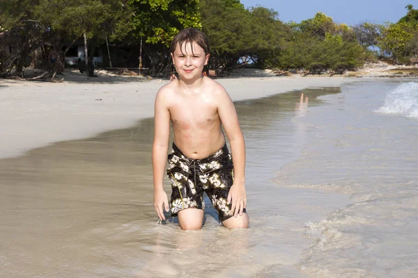 Giovane Ragazzo Gode Seduto Spiaggia Nello Spume — Foto Stock