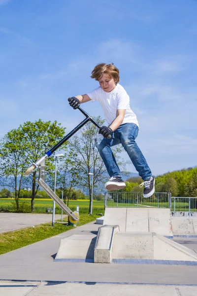 Jonge Jongen Heeft Leuke Springen Met Push Scooter Skatepark — Stockfoto