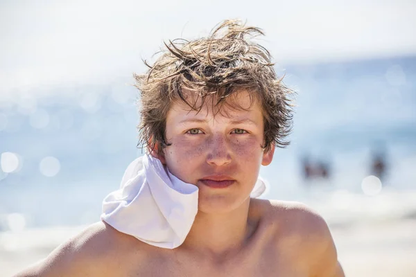 严重看起来十几岁的男孩湿头发在海滩上 — 图库照片