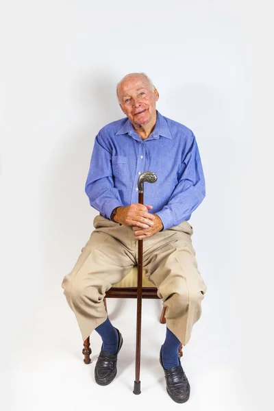 Glücklicher Älterer Mann Sitzt Vor Weißem Hintergrund — Stockfoto