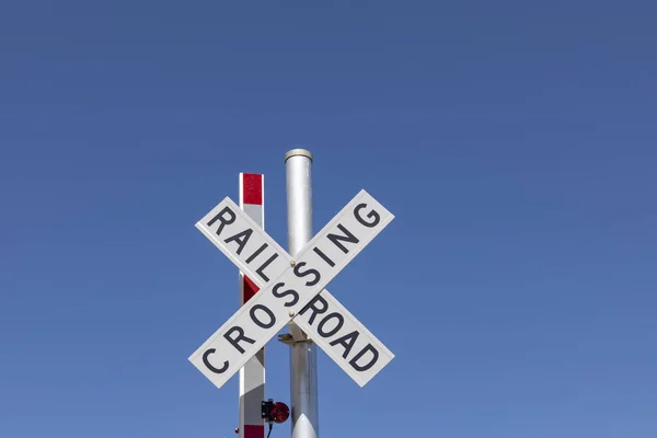 Železniční přejezd znamení pod modrou oblohou — Stock fotografie