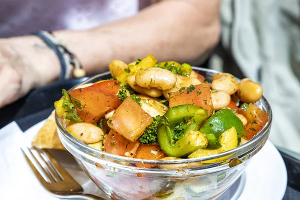 Ensalada de verano con tomates, frijoles, cebollas, pimentón, aceite, hierbas en un gl — Foto de Stock