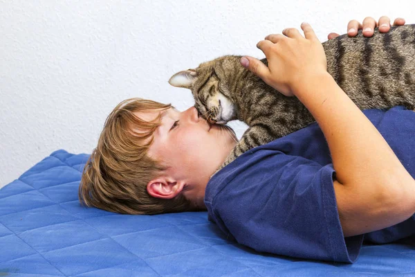 Милий хлопчик обіймається зі своїм котом — стокове фото