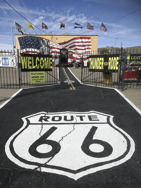 Route 66 op straat geschilderd met een typische route 66 shop in t — Stockfoto