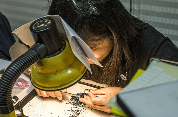 Female goldsmith prepares a ring with gemstones — Stock Photo, Image