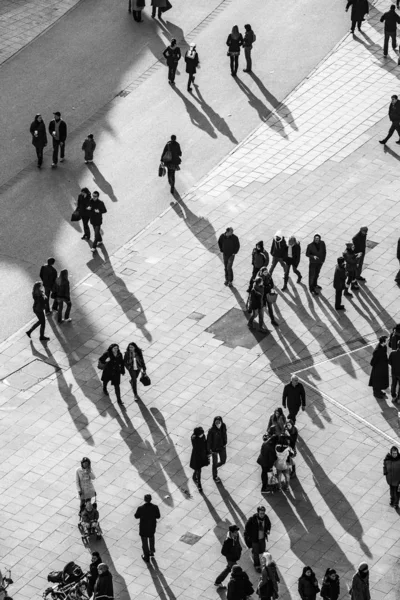 Pessoas andando na rua com longas sombras — Fotografia de Stock