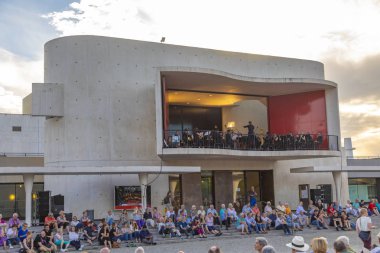 İnsanlar filarmoni orkestrasının açık hava konserinin tadını çıkarıyor. 